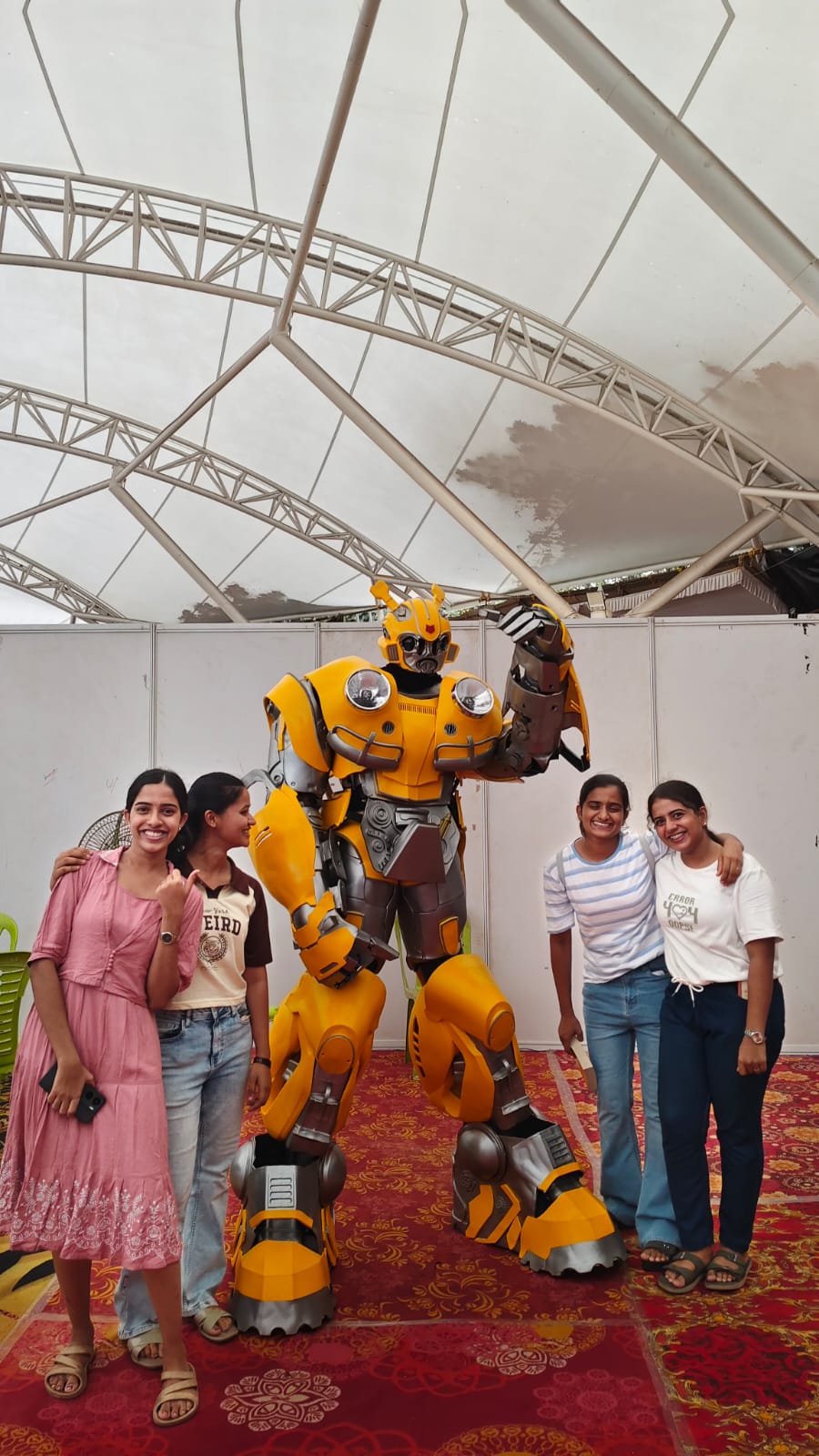 Child posing next to the life-size Zentroniq Bumblebee character at an event