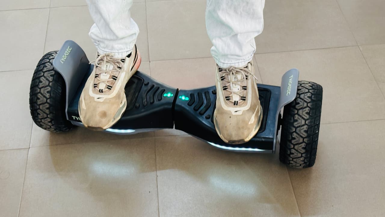 Student riding a Zentroniq hoverboard in front of a school crowd